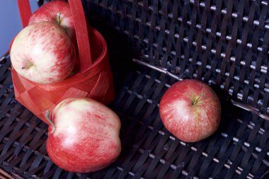 Olgun aromatik elma kırmızı hasır sepetin içinde. Hasır bir hasır sepet arka planı.