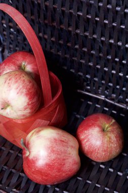 Olgun aromatik elma kırmızı hasır sepetin içinde. Hasır bir hasır sepet arka planı.