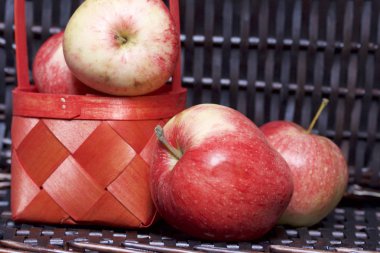 Olgun aromatik elma kırmızı hasır sepetin içinde. Hasır bir hasır sepet arka planı.