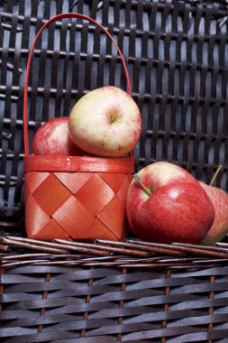 Olgun aromatik elma kırmızı hasır sepetin içinde. Hasır bir hasır sepet arka planı.