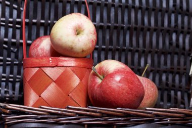 Olgun aromatik elma kırmızı hasır sepetin içinde. Hasır bir hasır sepet arka planı.