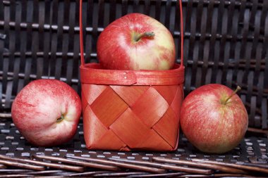 Olgun aromatik elma kırmızı hasır sepetin içinde. Hasır bir hasır sepet arka planı.