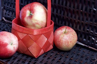 Olgun aromatik elma kırmızı hasır sepetin içinde. Hasır bir hasır sepet arka planı.