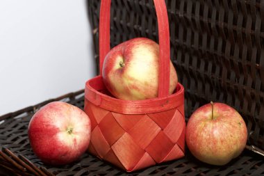 Olgun aromatik elma kırmızı hasır sepetin içinde. Hasır bir hasır sepet arka planı.