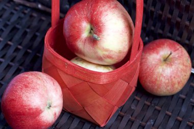 Olgun aromatik elma kırmızı hasır sepetin içinde. Hasır bir hasır sepet arka planı.