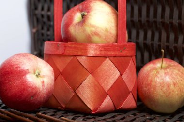 Olgun aromatik elma kırmızı hasır sepetin içinde. Hasır bir hasır sepet arka planı.