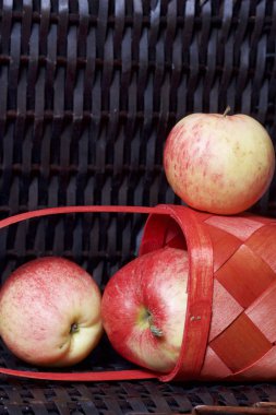 Olgun aromatik elma kırmızı hasır sepetin içinde. Hasır bir hasır sepet arka planı.