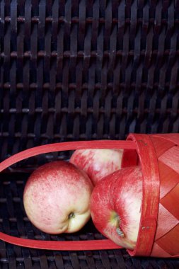 Olgun aromatik elma kırmızı hasır sepetin içinde. Hasır bir hasır sepet arka planı.