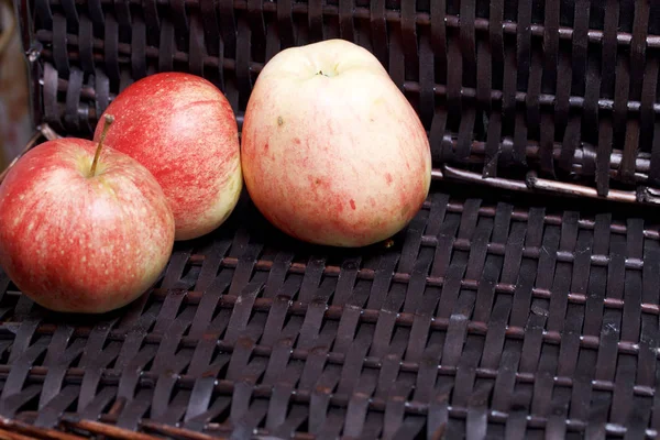Bir hasır sepet Vines arka plan üzerinde olgunlaşmış aromatik elma.
