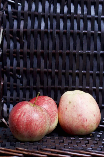 Bir hasır sepet Vines arka plan üzerinde olgunlaşmış aromatik elma.