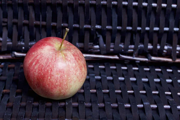 Bir hasır sepet Vines arka plan üzerinde olgunlaşmış aromatik elma.