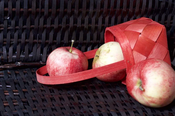 Olgun aromatik elma kırmızı hasır sepetin içinde. Hasır bir hasır sepet arka planı.