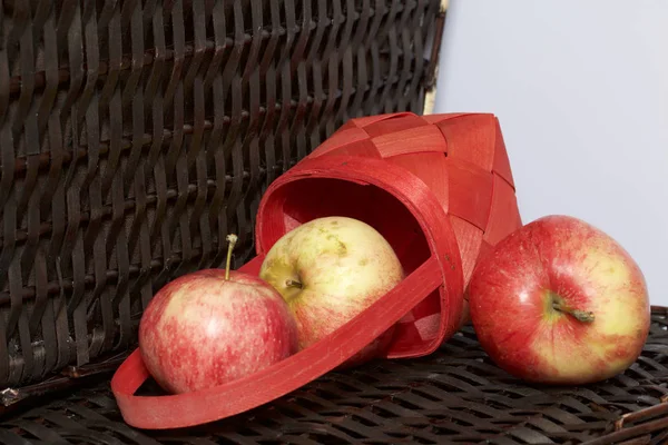 Olgun aromatik elma kırmızı hasır sepetin içinde. Hasır bir hasır sepet arka planı.