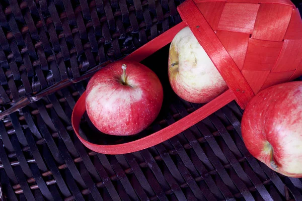 Olgun aromatik elma kırmızı hasır sepetin içinde. Hasır bir hasır sepet arka planı.