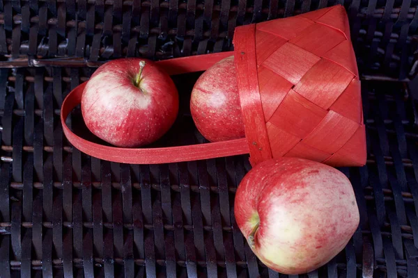 Olgun aromatik elma kırmızı hasır sepetin içinde. Hasır bir hasır sepet arka planı.