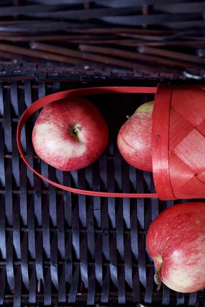 Olgun aromatik elma kırmızı hasır sepetin içinde. Hasır bir hasır sepet arka planı.