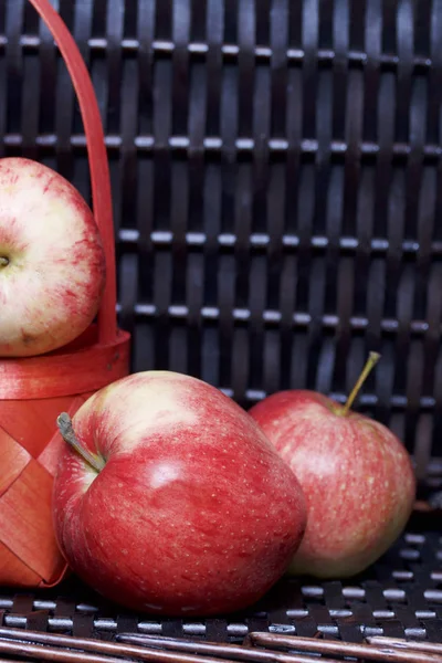 Olgun aromatik elma kırmızı hasır sepetin içinde. Hasır bir hasır sepet arka planı.