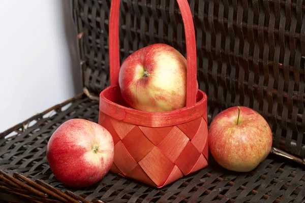 Olgun aromatik elma kırmızı hasır sepetin içinde. Hasır bir hasır sepet arka planı.