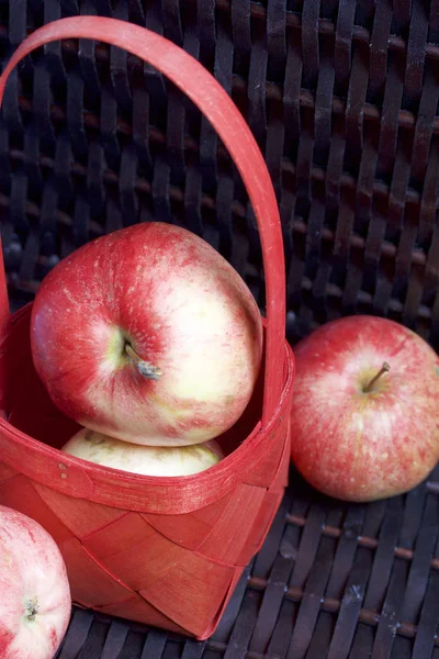 Olgun aromatik elma kırmızı hasır sepetin içinde. Hasır bir hasır sepet arka planı.