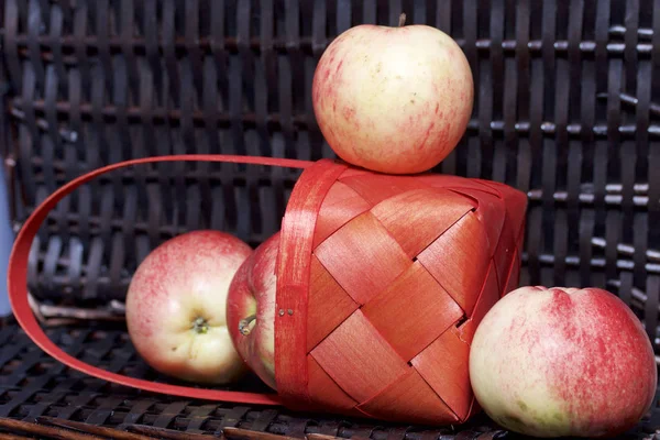 Olgun aromatik elma kırmızı hasır sepetin içinde. Hasır bir hasır sepet arka planı.