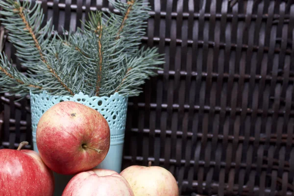 Mavi Ladin ve olgunlaşmış kokulu elma dalı. Hasır bir hasır sepet arka planı.