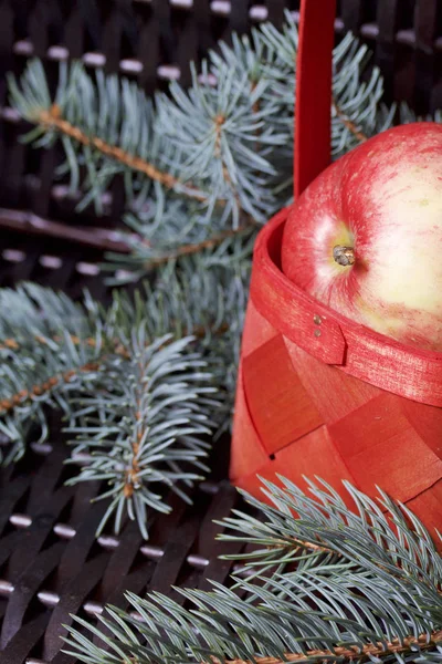 Mavi Ladin ve sepet içinde olgunlaşmış kokulu elma dalı. Bir hasır asma arka planı.