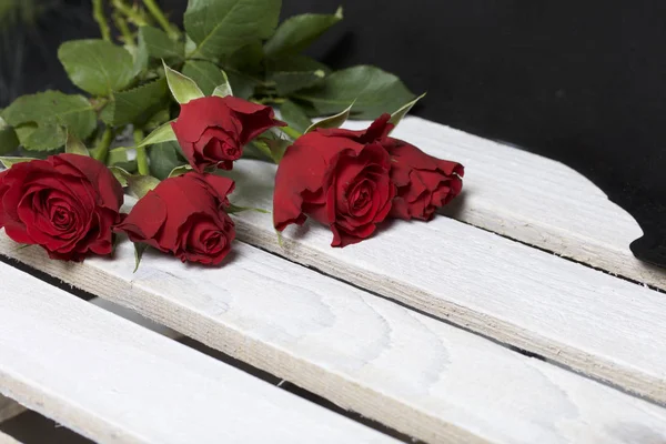 Bouquet Scarlet Roses Five Flowers Lie Wooden Box Black Background — Stock Photo, Image