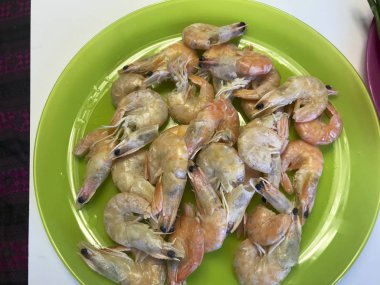 Haşlanmış karides bir tabak içinde yalan. Buhar onlardan geliyor.