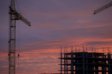 Kule vinç bir bina inşaat betonarme bir çerçeve ile. Şafak arka plan üzerinde.