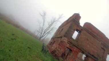 Eski bir kırmızı tuğla bina kalıntıları. Her şey kalın sis içinde kefen