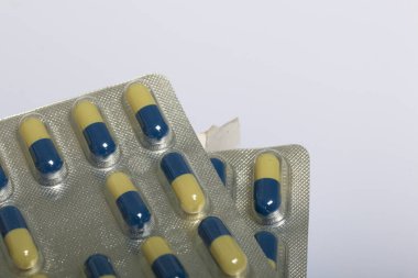 Tablet bir blister içinde kapsül şeklinde. Beyaz bir arka plan üzerinde.