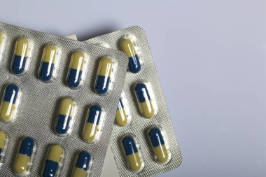 Tablet bir blister içinde kapsül şeklinde. Beyaz bir arka plan üzerinde.