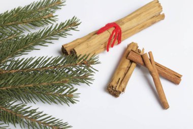 Tarçın ve bakla çam dalları yanındaki kırmızı biber. Beyaz bir arka plan üzerinde.