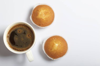 Bir bardak taze demlenmiş kahve ve çörek. Beyaz bir arka plan üzerinde.