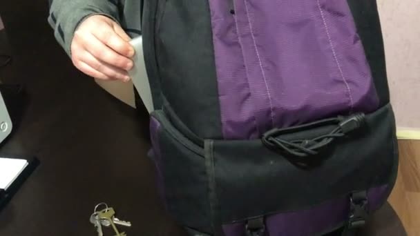 Ein Junger Mann Steckt Einen Laptop Einen Rucksack Nimmt Die — Stockvideo