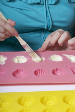 Bir kadın bir fırçayla eritilmiş çikolata silikon kalıp tatlı fırçalar.