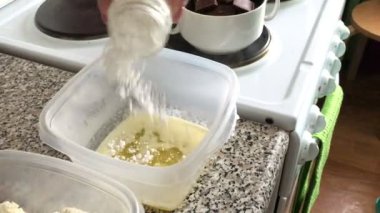  Bir kadın pudra şekeri bir kapta eritilmiş tereyağı ile ekler. Tatlı için malzemeler.