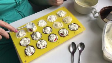 Kadın ile eritilmiş beyaz ve koyu çikolata bulaşmış bir silikon kalıp doldurma lor koyar. Tatlı yemek