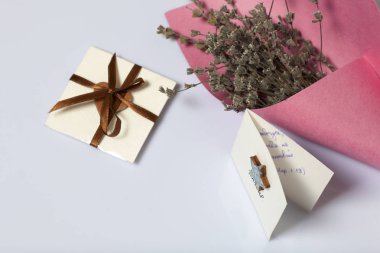 Renkli kağıda sarılmış Kuru çiçekler Buket. Küçük bir tebrik kartı. Beyaz bir arka plan üzerinde.