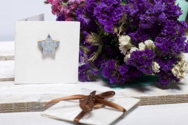 Renkli kağıda sarılmış Kuru çiçekler Buket. Küçük bir tebrik kartı.