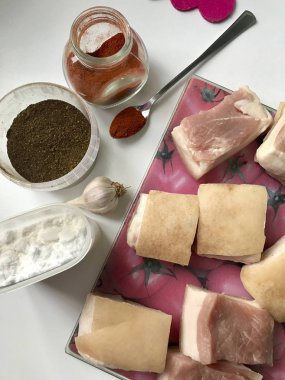 Parçalar halinde kesilmiş et tabaka ile domuz domuz yağı. Kesme tahtası üzerinde yatıyor. Domuz yağı tuzlama için, sarımsak, tuz, baharat.