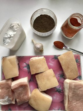 Parçalar halinde kesilmiş et tabaka ile domuz domuz yağı. Kesme tahtası üzerinde yatıyor. Domuz yağı tuzlama için, sarımsak, tuz, baharat.