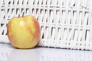 Apple masanın üzerinde. Yanındaki beyaz hasır sepetleri.