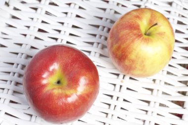 Sulu lezzetli elma. Yalanlar üzerine bir beyaz hasır sepet.