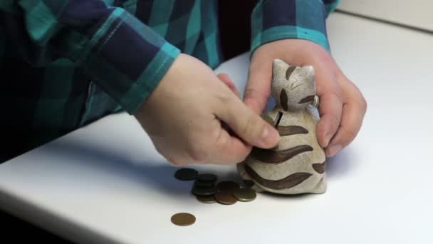 Tafel Een Spaarpot Vorm Van Een Kat Een Man Pikt — Stockvideo