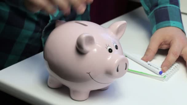 Mesa Hay Una Alcancía Forma Cerdo Rosa Hombre Pone Una — Vídeo de stock