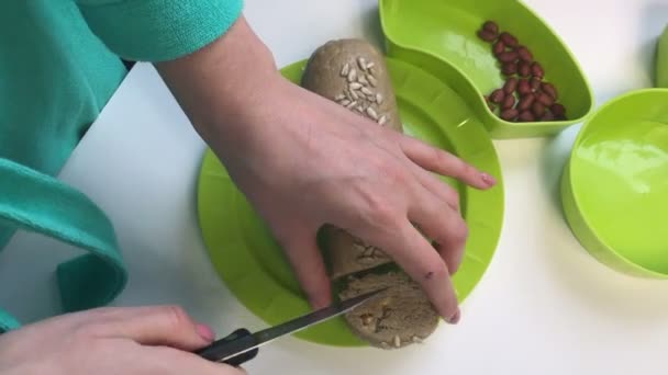 Woman Cuts Sausage Portions Mixture Crushed Peanuts Sunflower Seeds Honey — Stockvideo