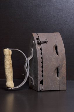 Eski demir, kömürü tarafından ısıtılır. Karanlık bir arka plan üzerinde bulunan.