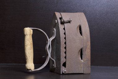 Eski demir, kömürü tarafından ısıtılır. Karanlık bir arka plan üzerinde bulunan.