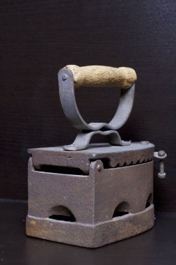 Eski demir, kömürü tarafından ısıtılır. Karanlık bir arka plan üzerinde bulunan.